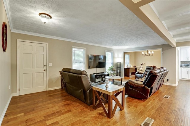537 Raven Springs Trl, Stone Mountain, GA 30087 - living room featuring a chandelier, light wood-type flooring, a textured ceiling, and crown molding