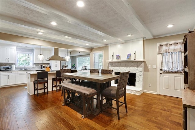 537 Raven Springs Trl, Stone Mountain, GA 30087 - dining area with dark wood-style floors, beamed ceiling, a fireplace, and recessed lighting