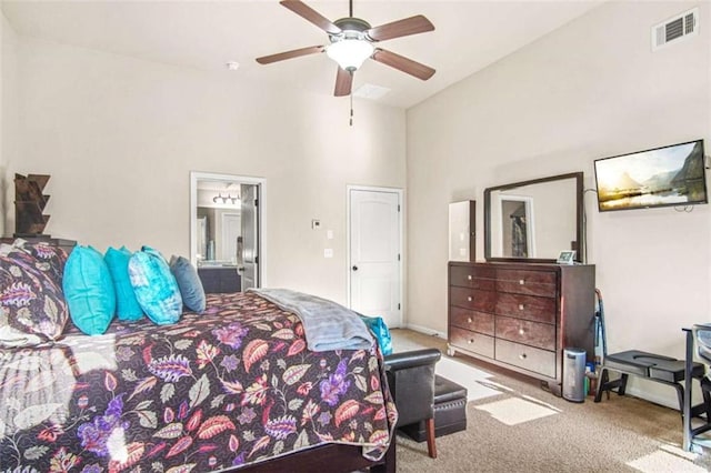 bedroom with ceiling fan, ensuite bathroom, light carpet, and high vaulted ceiling