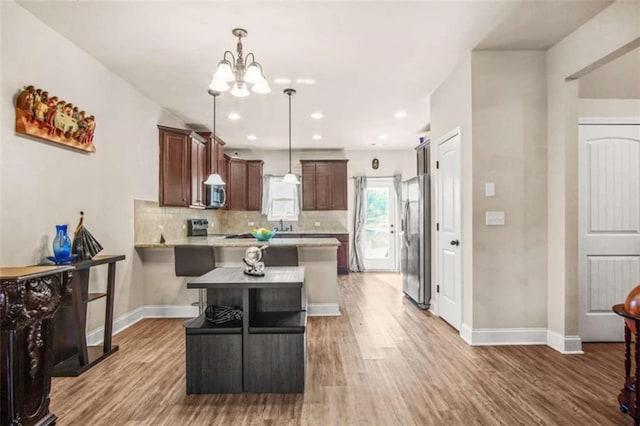 kitchen with appliances with stainless steel finishes, dark brown cabinetry, and wood-type flooring