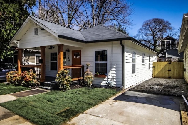 bungalow-style home featuring covered porch and a front yard