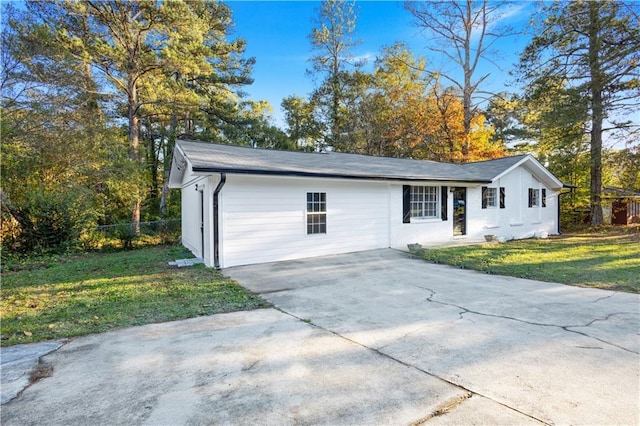 view of front of house featuring driveway, fence, and a front lawn