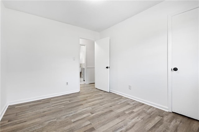 unfurnished bedroom featuring baseboards and wood finished floors