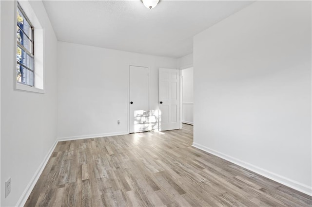 empty room featuring baseboards and wood finished floors