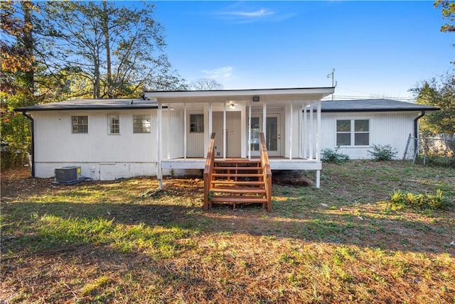 view of front of house featuring a porch, a front yard, and central AC unit