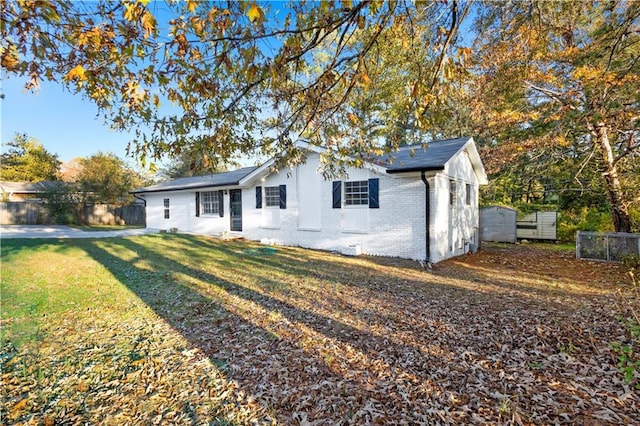 view of front of house with a front yard, brick siding, and fence