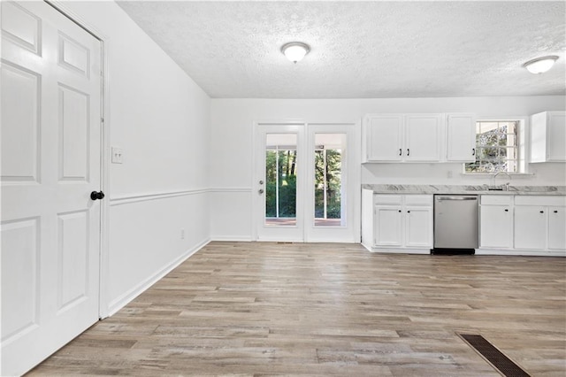 kitchen featuring light wood-style flooring, white cabinetry, and dishwasher