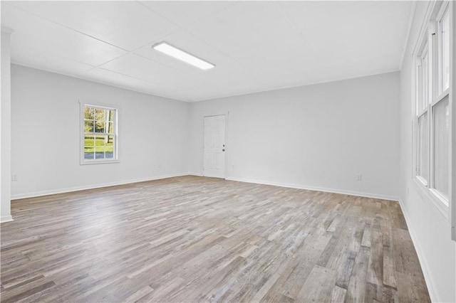 empty room featuring light wood-type flooring and baseboards