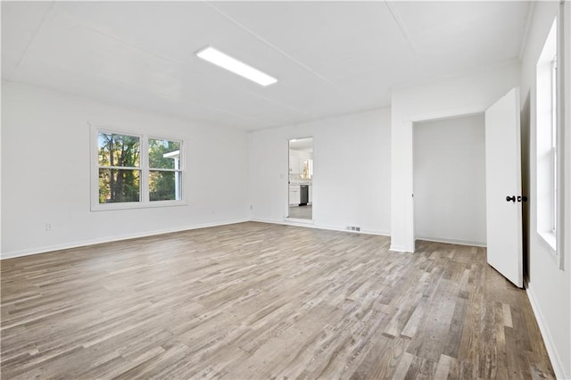 unfurnished room with visible vents, baseboards, and wood finished floors