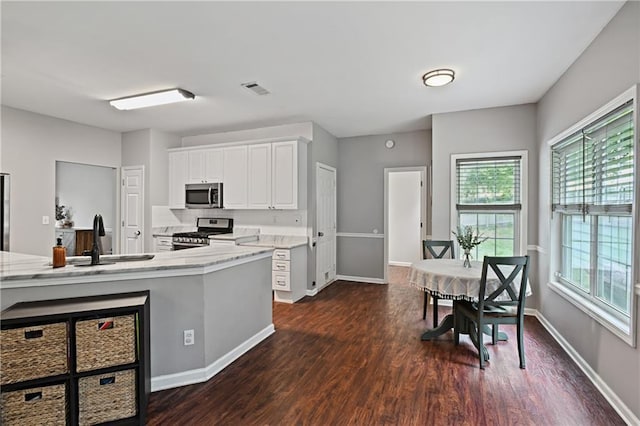 1185 Charter Club Dr, Lawrenceville, GA 30043 - kitchen with stainless steel appliances, a sink, dark wood-type flooring, and white cabinets