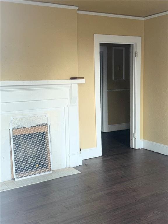 unfurnished living room with crown molding, dark hardwood / wood-style flooring, and a fireplace