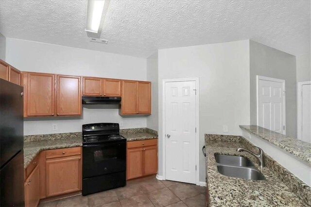 kitchen featuring sink, stone countertops, a textured ceiling, black appliances, and tile patterned floors