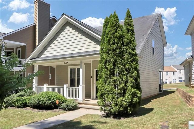 view of front of property with a front yard and covered porch