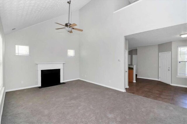 unfurnished living room featuring ceiling fan, dark carpet, a textured ceiling, and high vaulted ceiling