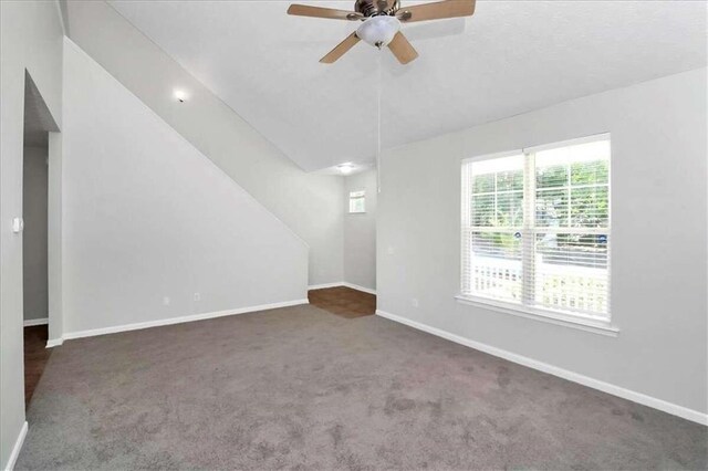 carpeted spare room with vaulted ceiling and ceiling fan