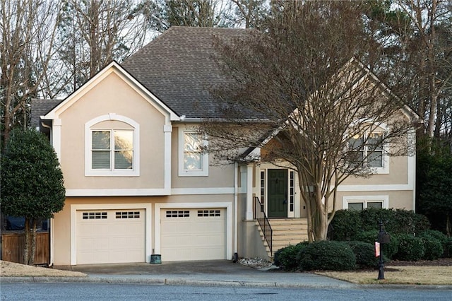 view of front of house featuring a garage, roof with shingles, driveway, and stucco siding