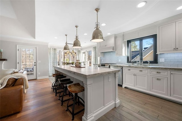 kitchen featuring light wood-style floors, crown molding, appliances with stainless steel finishes, and a sink