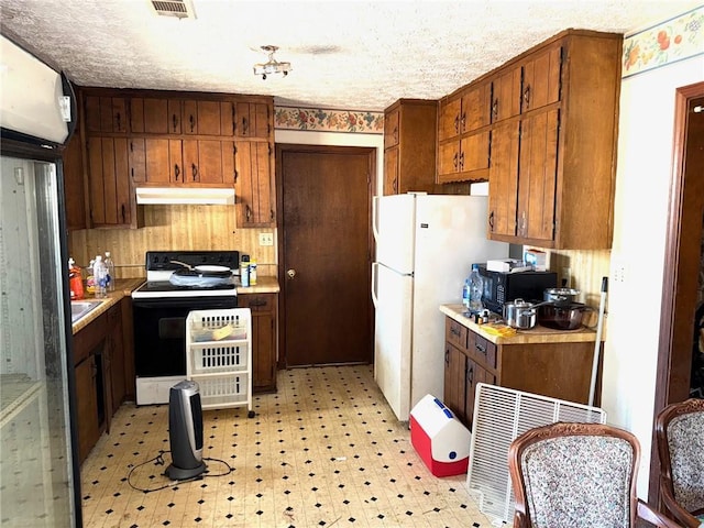 kitchen featuring white appliances and a textured ceiling