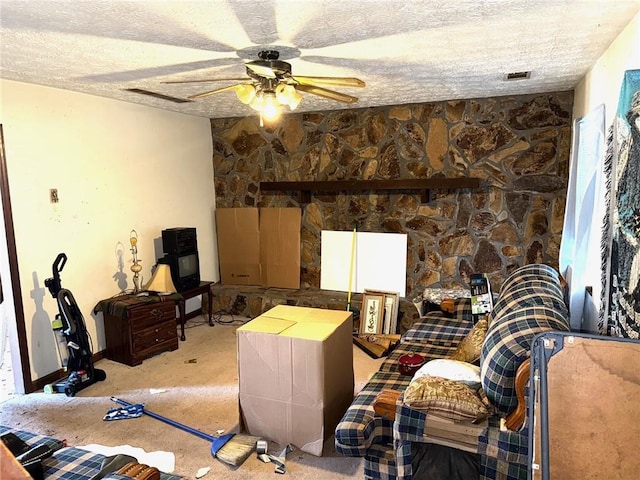 interior space with a textured ceiling, light colored carpet, and ceiling fan