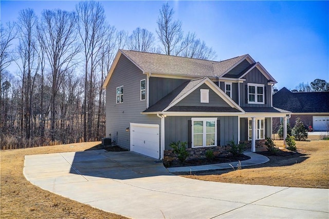 craftsman-style home with central AC unit, an attached garage, concrete driveway, stone siding, and board and batten siding