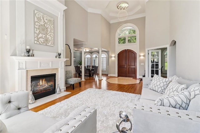 1213 Grande Vw, Loganville, GA 30052 - living area featuring a high ceiling, wood finished floors, crown molding, and a glass covered fireplace