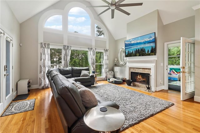 1213 Grande Vw, Loganville, GA 30052 - living room featuring a ceiling fan, a warm lit fireplace, wood finished floors, and high vaulted ceiling