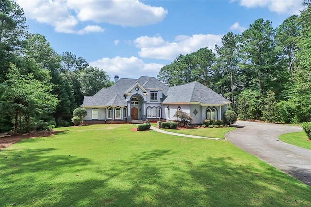 1213 Grande Vw, Loganville, GA 30052 - view of front of house with a front lawn, asphalt driveway, a chimney, and stucco siding