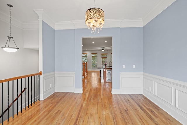 interior space with crown molding, sink, a notable chandelier, and light hardwood / wood-style floors