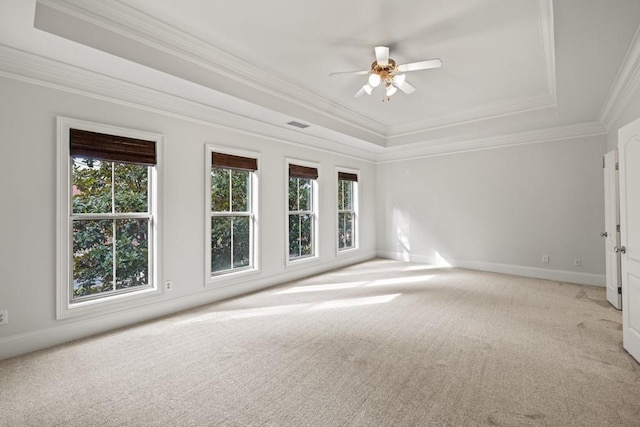 spare room featuring ceiling fan, ornamental molding, a raised ceiling, and light carpet