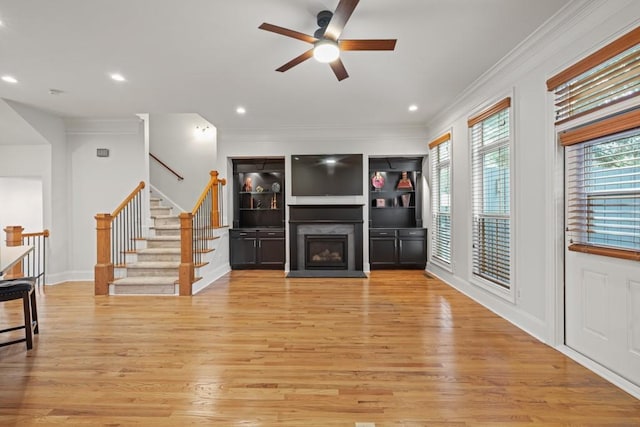 living room with crown molding, ceiling fan, and light hardwood / wood-style flooring