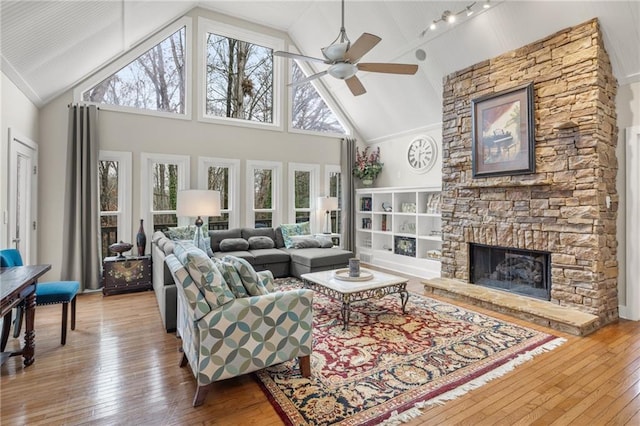 living room featuring hardwood / wood-style floors, a stone fireplace, and plenty of natural light