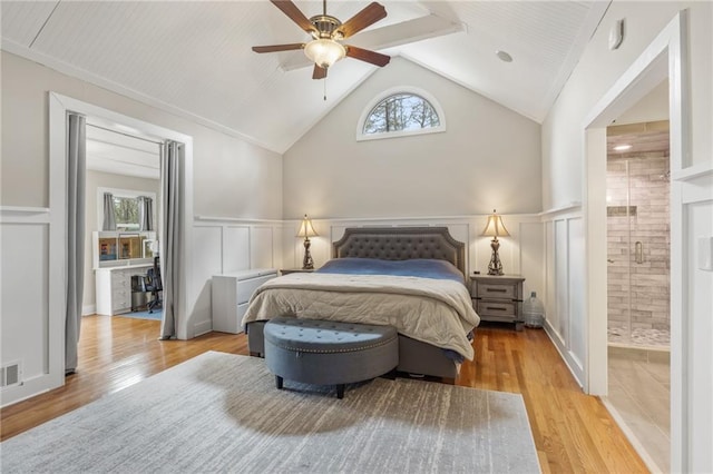 bedroom with ceiling fan, lofted ceiling, light hardwood / wood-style flooring, and ensuite bath