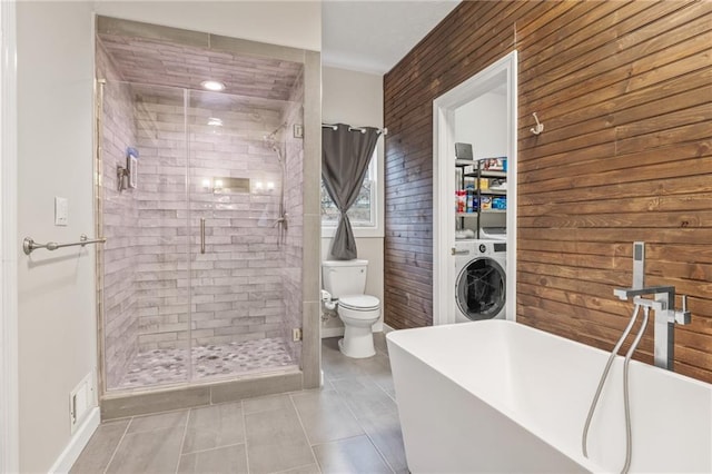 bathroom with tile patterned floors, washer / clothes dryer, plus walk in shower, and toilet