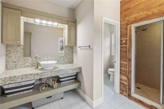 bathroom featuring tile patterned flooring, backsplash, toilet, and sink