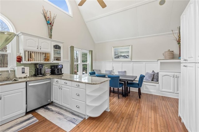 kitchen featuring stone counters, dishwasher, kitchen peninsula, white cabinets, and light wood-type flooring