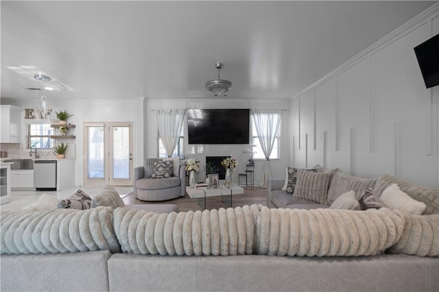 living room featuring hardwood / wood-style floors, sink, and ornamental molding