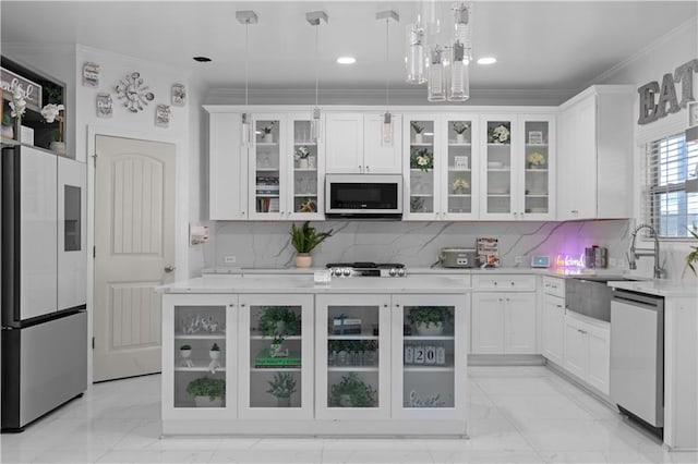 kitchen with white cabinets, tasteful backsplash, crown molding, appliances with stainless steel finishes, and decorative light fixtures