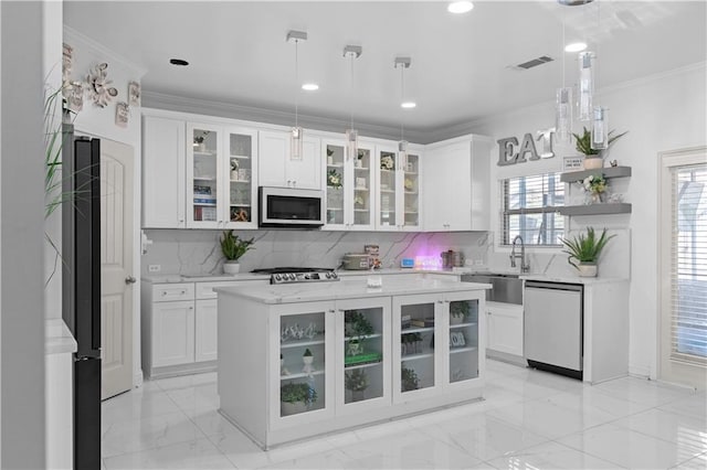 kitchen featuring a kitchen island, white cabinetry, appliances with stainless steel finishes, and hanging light fixtures