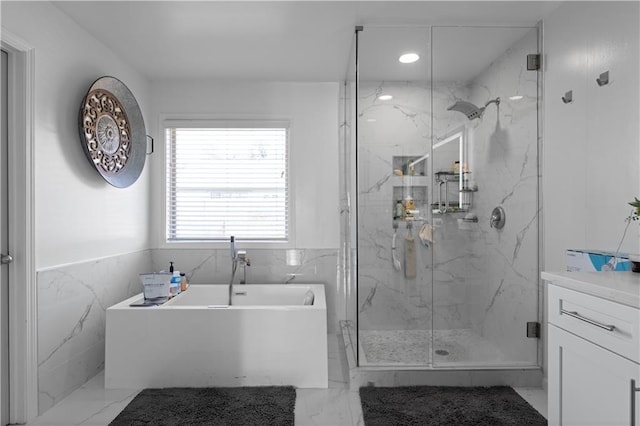 bathroom with tile walls, shower with separate bathtub, and vanity