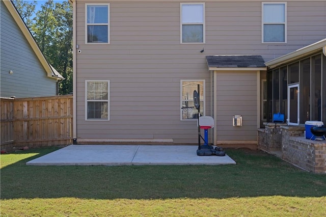 rear view of house featuring a patio, a sunroom, and a yard