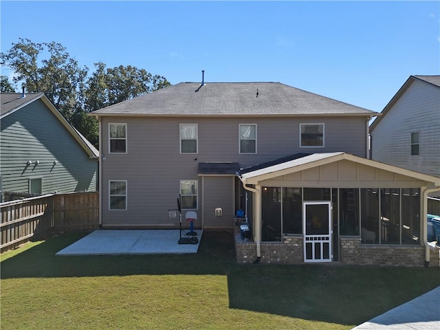 back of property with a patio area, a sunroom, and a yard