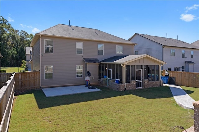 back of property with a lawn, a sunroom, and a patio