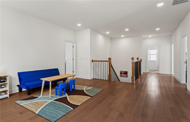 interior space with visible vents, recessed lighting, wood finished floors, an upstairs landing, and baseboards