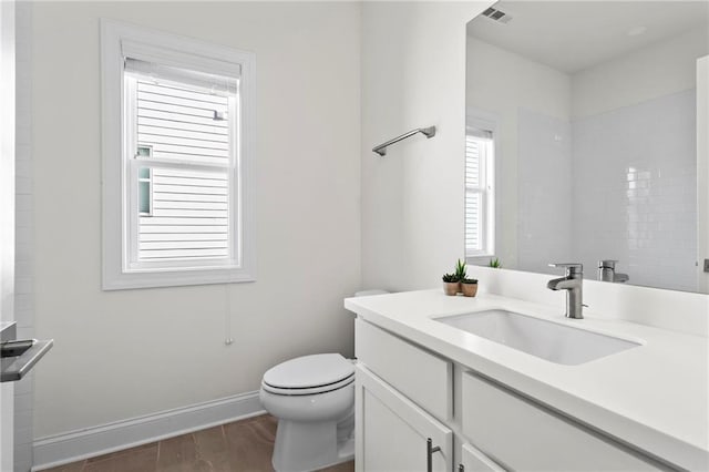full bath featuring visible vents, baseboards, toilet, vanity, and wood finished floors