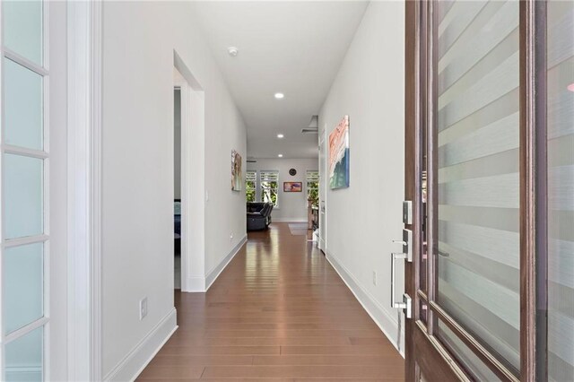 corridor featuring recessed lighting, baseboards, and wood finished floors