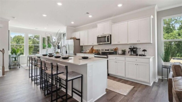 204 College Cir Unit 1003, Hapeville, GA 30354 - kitchen with a breakfast bar, dark hardwood / wood-style floors, white cabinetry, a kitchen island with sink, and stainless steel appliances