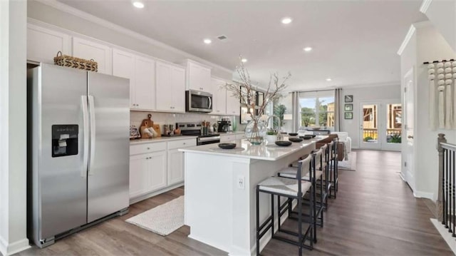 204 College Cir Unit 1003, Hapeville, GA 30354 - kitchen with an island with sink, appliances with stainless steel finishes, white cabinets, and a kitchen bar