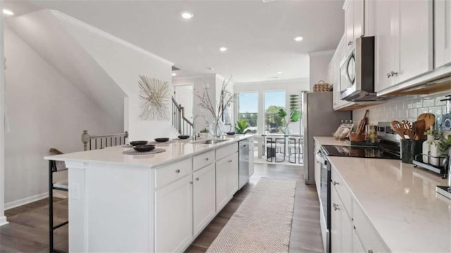204 College Cir Unit 1003, Hapeville, GA 30354 - kitchen with sink, a breakfast bar, stainless steel appliances, an island with sink, and white cabinets