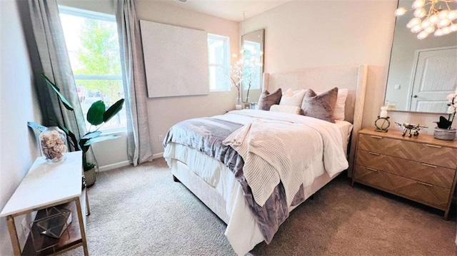 carpeted bedroom featuring a chandelier and multiple windows