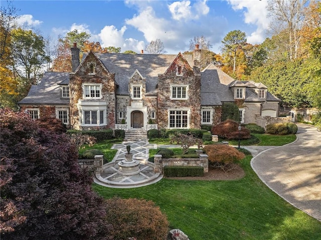 tudor-style house with a front lawn